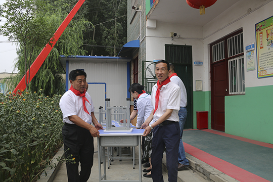 华亿(中国)一站式服务平台领导与学生一起将桌椅搬进教室