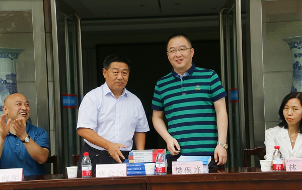 新乡市牧野区税务局党委书记、局长樊保峰向华亿(中国)一站式服务平台党委书记张会民赠送税法知识书籍.jpg